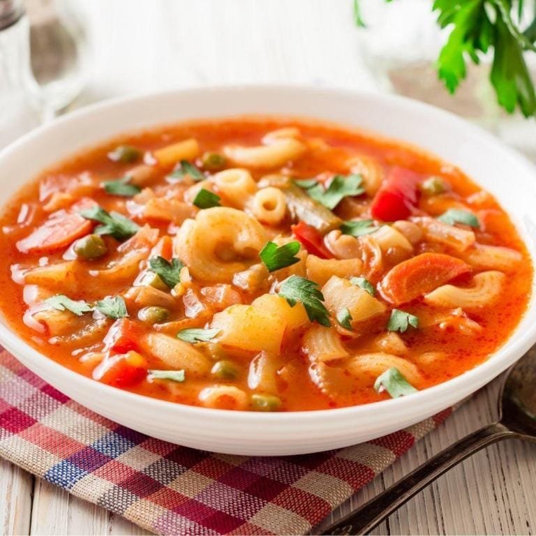 Orijinal Minestrone çorbası tarifi: Havuç, fasulye ve çeşitli mevsim sebzeleriyle hazırlanmış, doyurucu İtalyan sebze çorbası rustik bir kasede sıcak servis ediliyor.