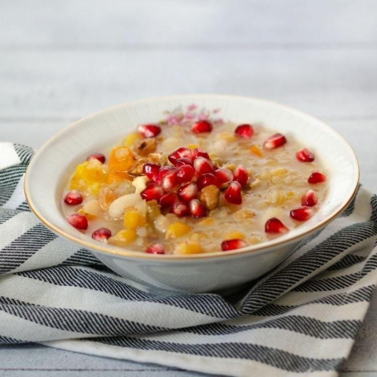 Nar taneleri, ceviz, fındık ve kuru meyvelerle zengin bir şekilde süslenmiş, buğday ve bakliyatlarla hazırlanmış, tam kıvamında, iştah açıcı geleneksel aşure