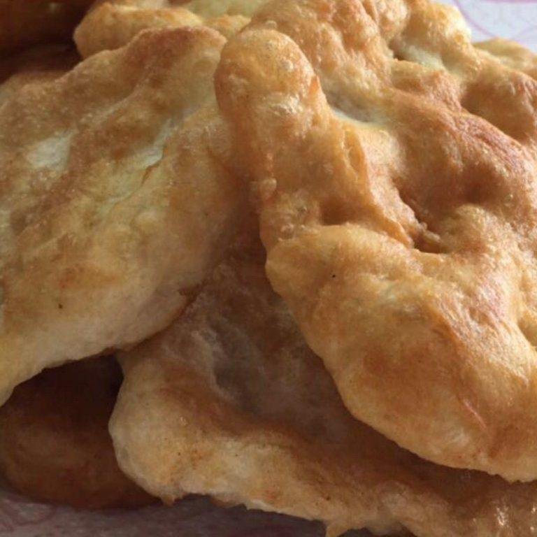 Sıcak yağda altın rengini almış puf puf kabaran geleneksel pişi görüntüsü, servis tabağında buharı tüten taze pişi halkaları ve yanında peynir-zeytin eşliğinde sunum