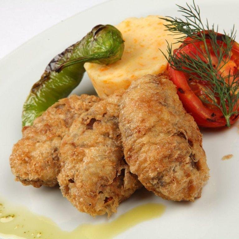 Kadınbudu köfte tarifi & Köfte tarifi - Orijinal kadınbudu köfte tarifi: Dışı altın rengi galeta unu kaplamalı, içi pirinçli ve yumuşacık olan köfteler patates püresi eşliğinde servis tabağında sunuluyor.