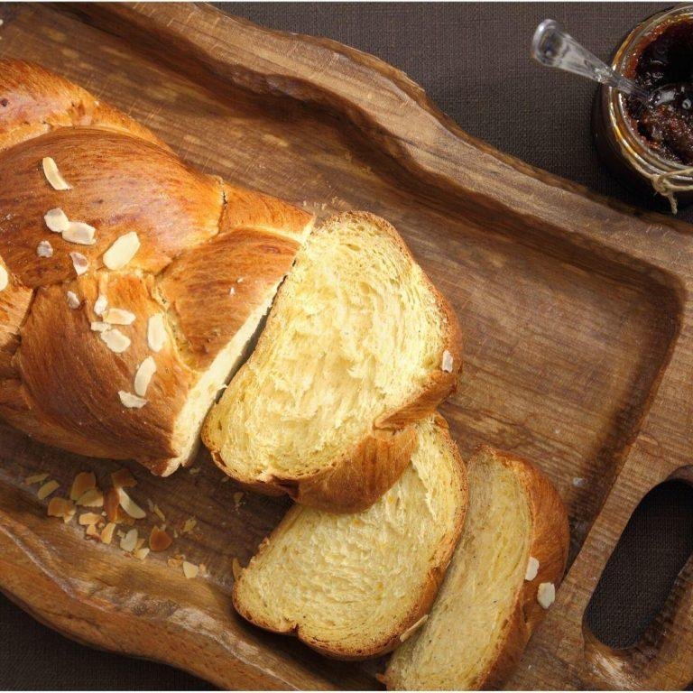 Altın renginde kızarmış, üzeri file bademle bezeli, mahlep ve damla sakızı aromalı, saç örgüsü şeklinde hazırlanmış geleneksel paskalya çöreği görüntüsü