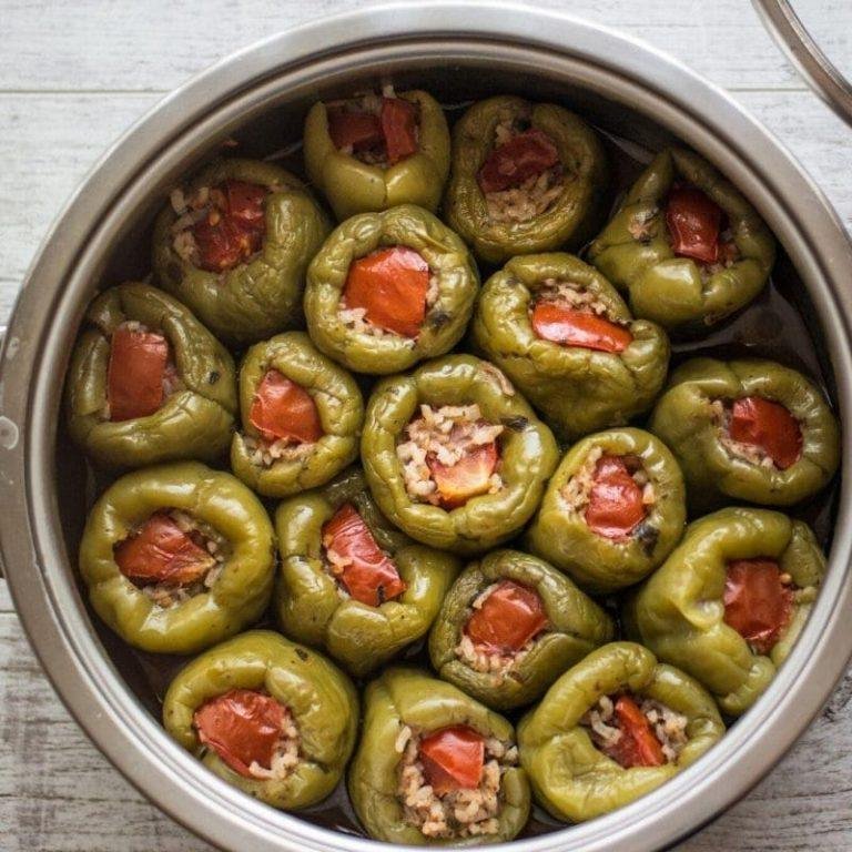 Kıymalı biber dolması; sarımsaklı yoğurtla servis edilen, pirinçli iç harcıyla dolu nefis biberlerin kızarmış üstüyle sofranızı şenlendirecek ev yapımı lezzet!