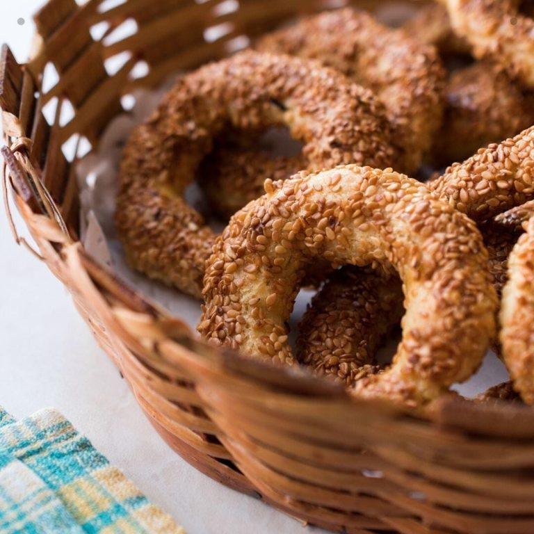 Kandil Simidi Tarifi - Mahlepli, susamlı, altın renginde çıtır çıtır kandil simitleri; geleneksel sunumuyla fırından taze çıkmış haliyle servis tabağında yer alıyor.