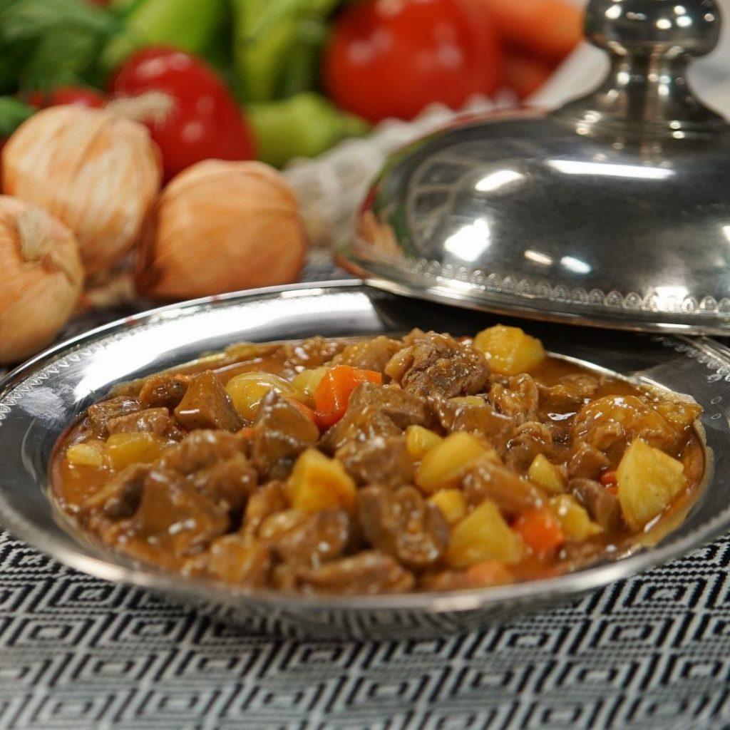 Tas kebabı tabakta; dana kuşbaşı, havuç ve patates, kıvamlı kırmızımsı sos