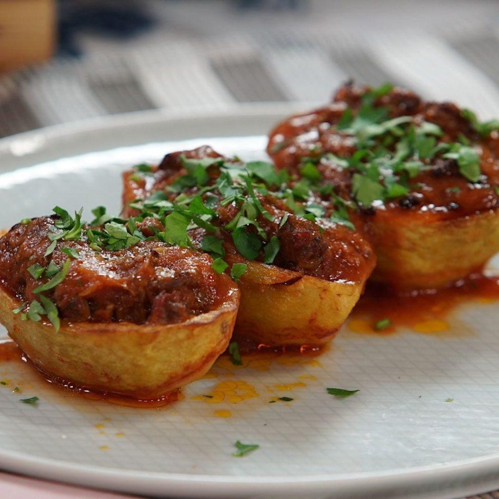 Patates karnıyarık; ikiye bölünüp kızarmış patatesler, içi kıymalı domatesli harç