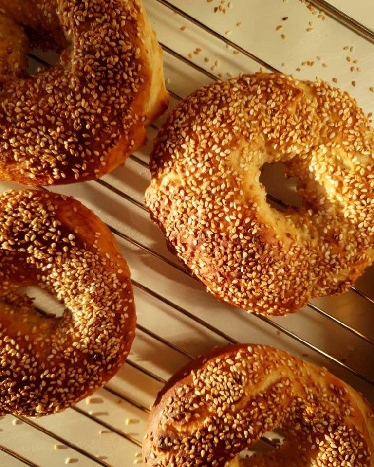 Altın renginde, susama doyurulmuş, fırından yeni çıkmış pastane simidi - evde kolayca hazırlanan yumuşacık iç dokulu simitler keşfedin!