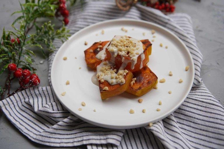 Fırında yavaşça karamelize olmuş, kehribar rengi doğal balkabağı dilimlerinin şeffaf şerbetle parladığı, ağızda dağılan yumuşacık kıvamıyla dikkat çeken, üzeri nar gibi kızarmış, taze çekilmiş ceviz ve parlak tahinle süslenmiş iştah açıcı bir lezzet şöleni.