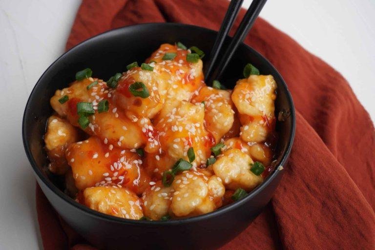 Tatlı Ekşi Soslu Tavuk Tarifi: Parlak ve kıvamlı tatlı ekşi sos ile kaplanmış çıtır tavuk parçaları, renkli biber ve ananas dilimleriyle zenginleşen, üzeri taze soğan ve susam taneleriyle süslenmiş iştah açıcı lezzet.