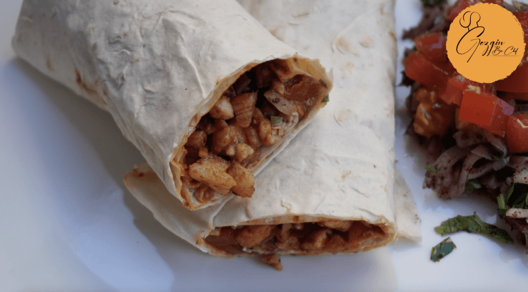 Baharatlarla harmanlanmış, özenle sotelenmiş ve tam kıvamında pişirilmiş sulu tavuk parçacıklarının, taze doğranmış domates, soğan ve maydanoz gibi doğal malzemelerle zenginleştirilerek yumuşacık lavaşa sarıldığı, her ısırıkta iştah kabartan, canlı renkli ve lezzet dolu bir Tavuk Tantuni dürümü.