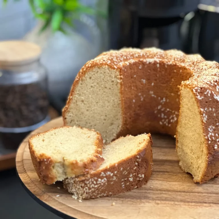 Tahinli Kek Tarifi: Üzeri bol susam ve cevizle süslenmiş, arasında tahin gezdirilmiş, yumuşacık dokulu, altın rengi dilimiyle iştah açan ev yapımı kek.