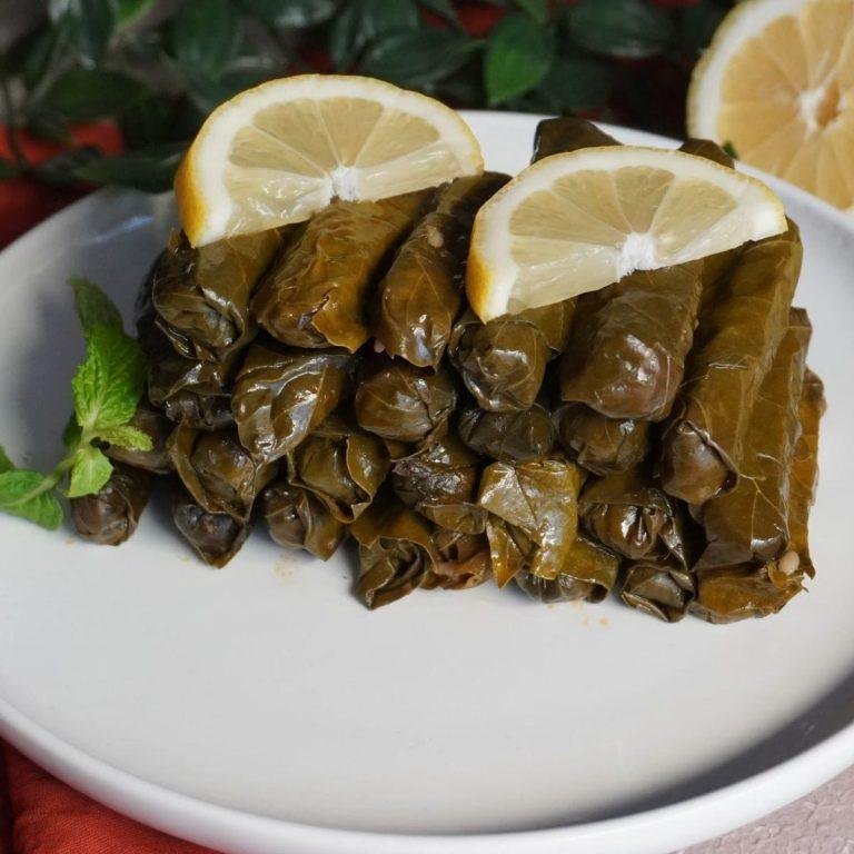 Ege Usulü Yaprak Sarması Tarifi: Taze asma yapraklarından kalem gibi sarılmış, bol zeytinyağı ile parlayan, limon dilimleriyle sunulan, lokum kıvamında, iştah açıcı zeytinyağlı yaprak sarması.