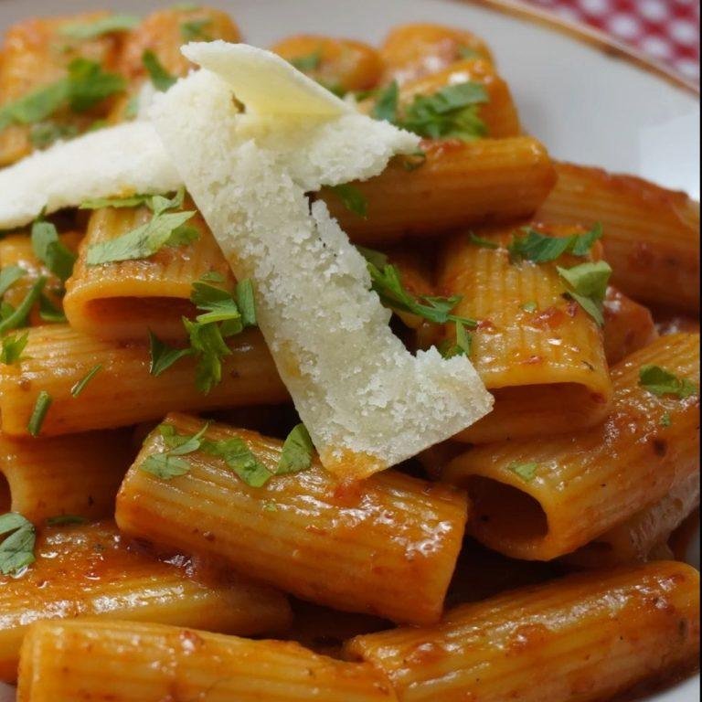 Kremalı domates sosuyla kaplanmış, parmesanla taçlandırılmış ve taze fesleğenle süslenmiş buharı üstünde Gigi Hadid makarnası tabağı