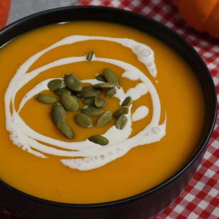 Fırında karamelize edilmiş Hokkaido kabağı ile hazırlanmış, buharda dağılan sıcak bir bal kabağı çorbası. Üzerinde krema ve çıtır kabak çekirdekleriyle süslenmiş tabakta servis edilen, besleyici, bebek ve yetişkinler için uygun, diyet dostu ve sütlü ya da sütsüz hazırlanabilen bal kabağı çorbası görünümü.