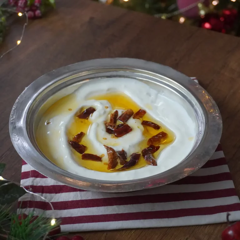 Atom Tarifi: Yoğun kıvamlı süzme yoğurt üzerine gezdirilmiş, kızgın tereyağında kavrulmuş çıtır kuru biberler ve parlak kırmızı yağıyla sunulan iştah açıcı atom mezesi.