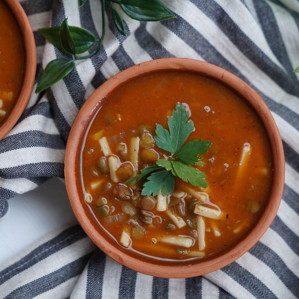 Fesleğen yapraklarıyla göz alıcı bir şekilde süslenmiş, derin ve doyurucu kırmızı-kahve tonlarındaki iştah açıcı erişte ve mercimek çorbası, zengin kıvamıyla doğal lezzetin sıcaklığını her lokmada hissettiriyor.