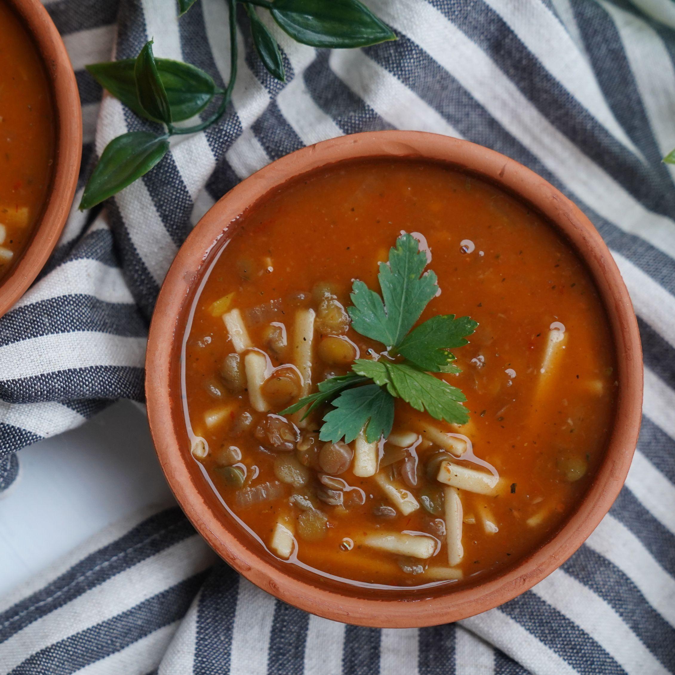 Fesleğen yapraklarıyla göz alıcı bir şekilde süslenmiş, derin ve doyurucu kırmızı-kahve tonlarındaki iştah açıcı erişte ve mercimek çorbası, zengin kıvamıyla doğal lezzetin sıcaklığını her lokmada hissettiriyor.