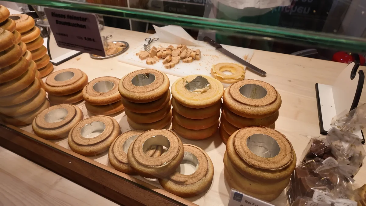 Layered Baumkuchen tree cakes lined up on a stall at a Cologne Christmas market