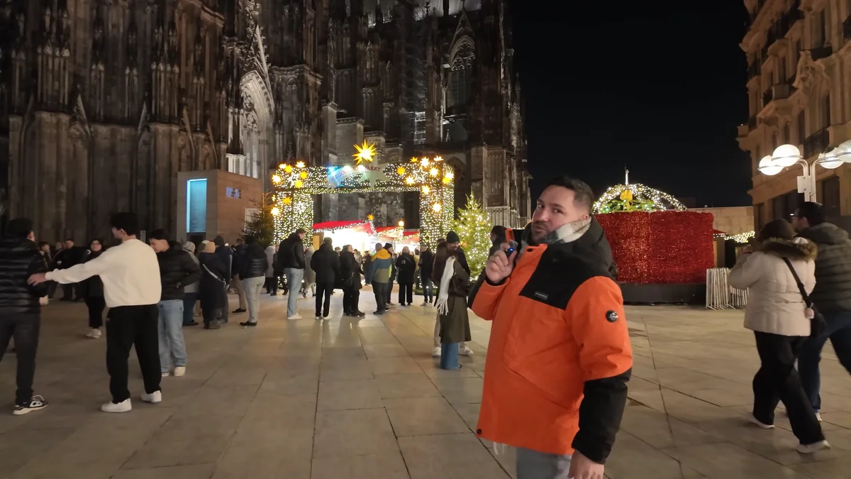 Halil in a thick winter coat on the square in front of Cologne Cathedral on a December evening