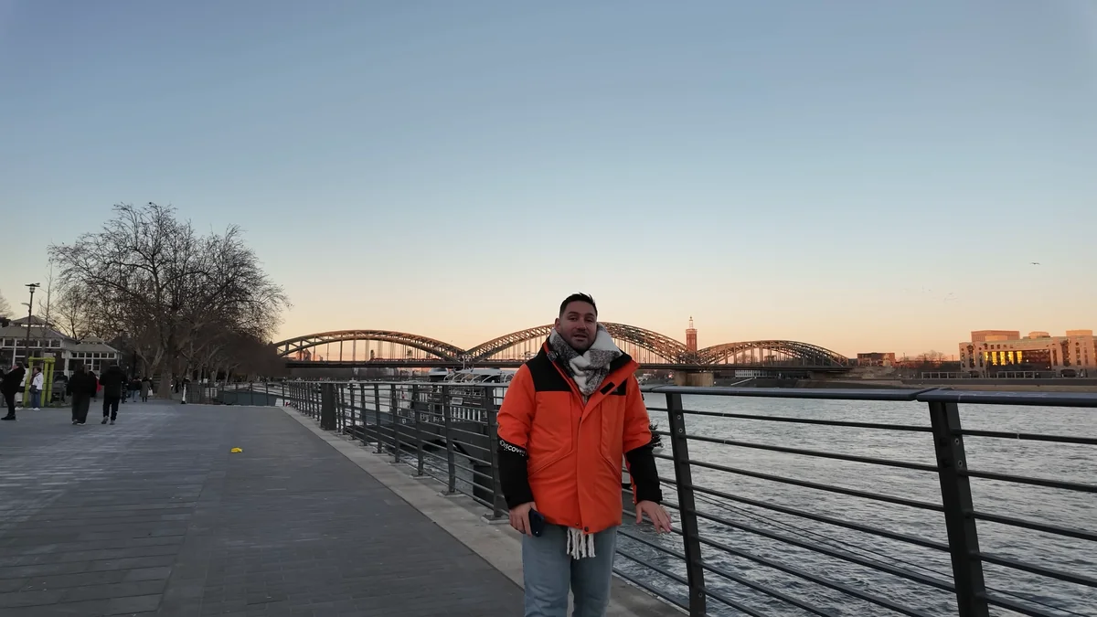 The riverside promenade on the Rhine in Cologne at sunset with the Hohenzollern Bridge behind