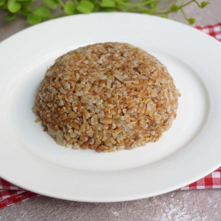 Siyez Bulguru Pilavı: Tane tane ayrılmış, buharı tüten altın sarısı siyez bulgurlarının oluşturduğu pilav, üzerinde taze yeşil fesleğen yapraklarıyla süslenmiş, hafif parlak ve kıvamlı doğal dokusuyla iştah kabartan bir sunum.