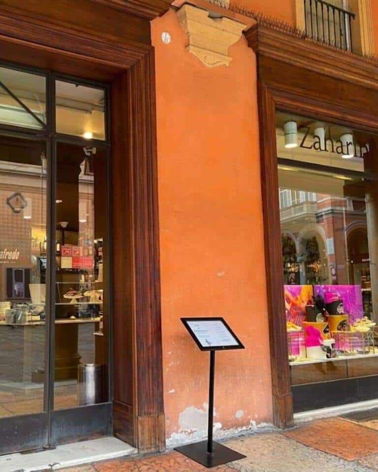Zanarini'nin şık kafesinde atıştırmalıklar eşliğinde sunulan bol buzlu klasik Aperol Spritz kokteyli, Piazza Galvani