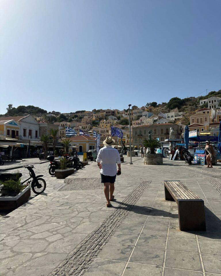 Symi Adası kordon boyu: Gezginbirchef Yunan bayrakları eşliğinde sahil yürüyüşünde.