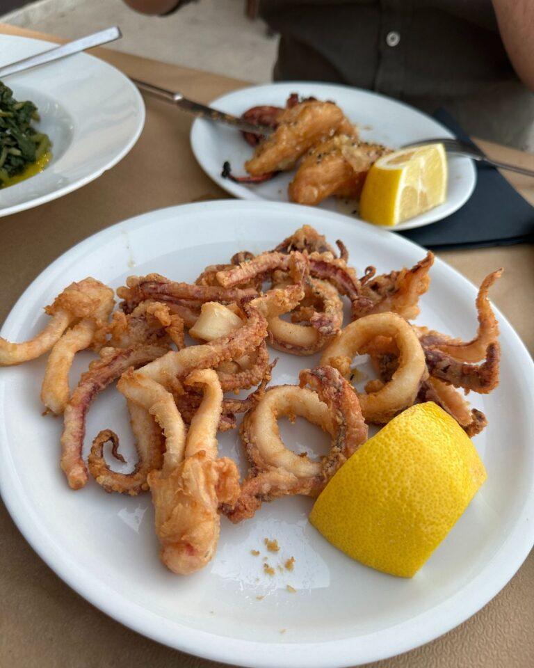 Symi Adası'nda bir restoranda servis edilmiş, yanında limon dilimi bulunan çıtır kalamar tava tabağı.