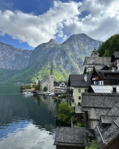 Hallstatt köyünün Evangelik Kilisesi ve tepedeki Katolik Maria am Berg Kilisesi ile geleneksel ahşap çatılı evlerin panoraması