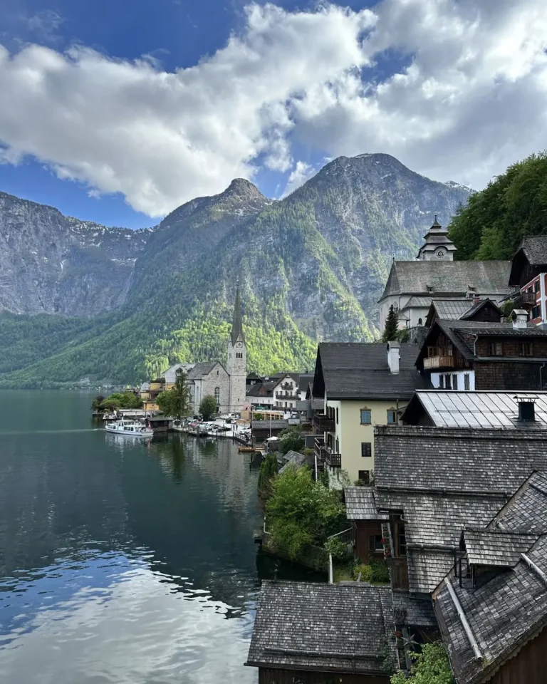 Hallstatt köyünün Evangelik Kilisesi ve tepedeki Katolik Maria am Berg Kilisesi ile geleneksel ahşap çatılı evlerin panoraması