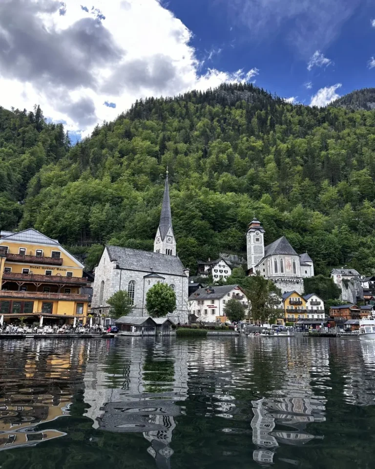 Hallstatt Evangelik Kilisesi, Katolik Maria am Berg Kilisesi ve Hotel Grüner Baum'un Hallstättersee göl yansımasıyla görünümü