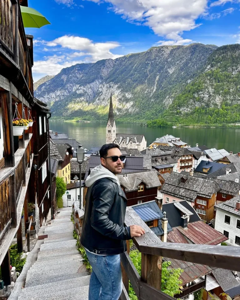 Hallstatt klasik fotoğraf noktasının ahşap korkuluğunda Gezginbirchef, arkada Evangelik Pfarrkirche kilisesi ve göl