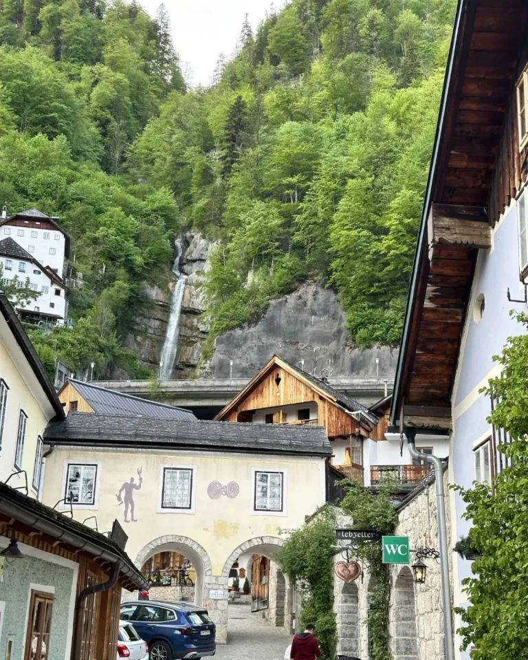 Hallstatt merkezdeki Mühlbach Şelalesi ve geleneksel Avusturya köy evleri, kemerli geçit ile Lebzelter dükkanı