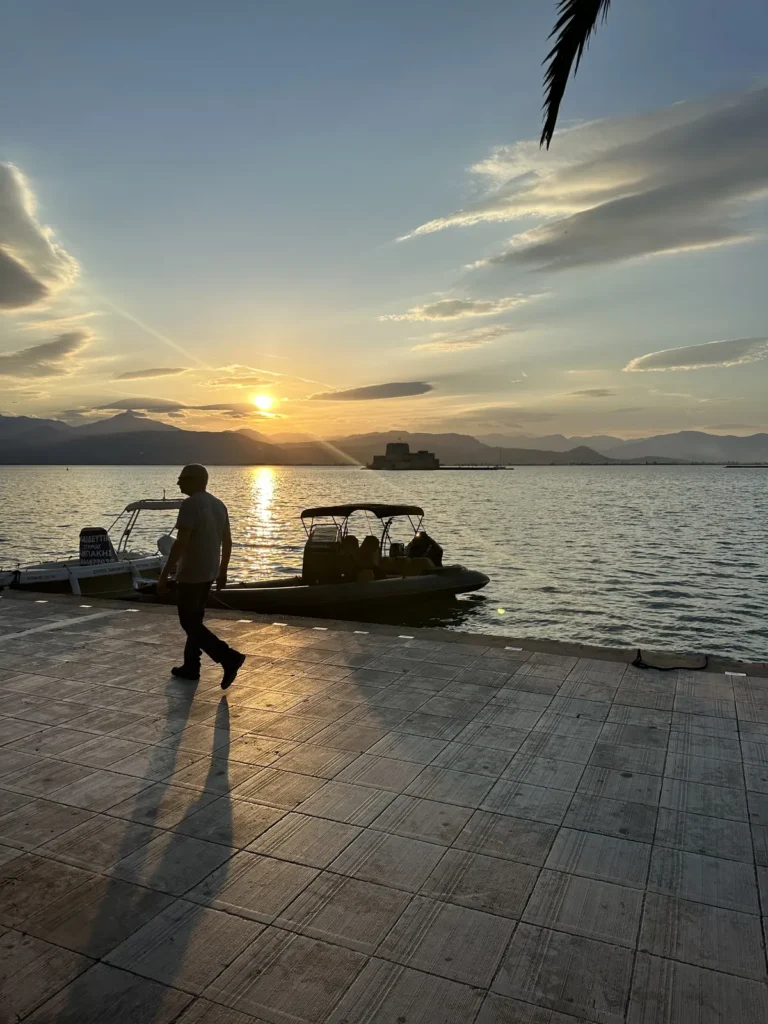 Nafplio'da körfez üzerinde gün batımı ve turuncu gökyüzü