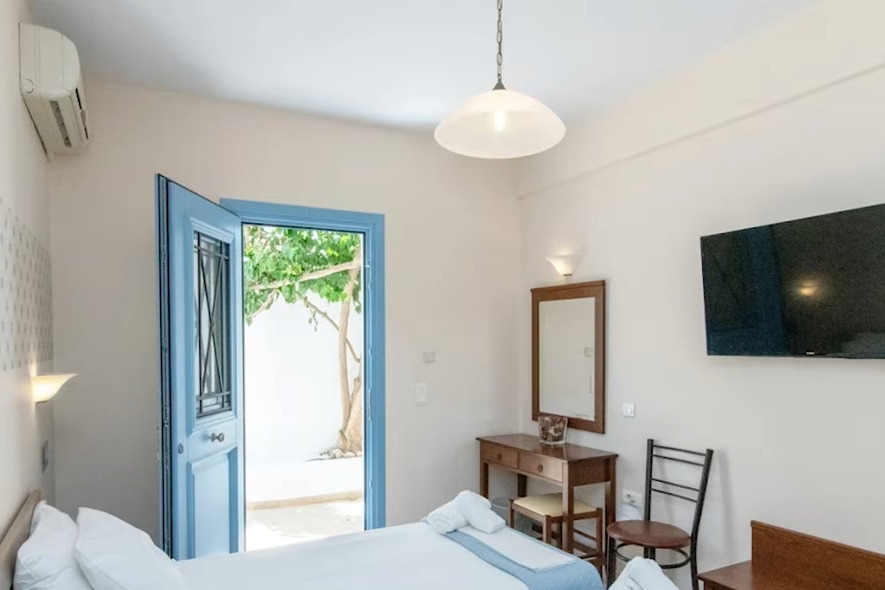 Agapi Hotel Tinos odası: mavi kapı, iki yatak ve avluya açılan giriş