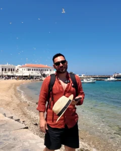 Mykonos (Mikonos) Adası Gezi Rehberi: A'dan Z'ye Seyahat İpuçları Mykonos Eski Liman sahilinde balıkçı tekneleri, martılar ve arkada beyaz Chora evleri