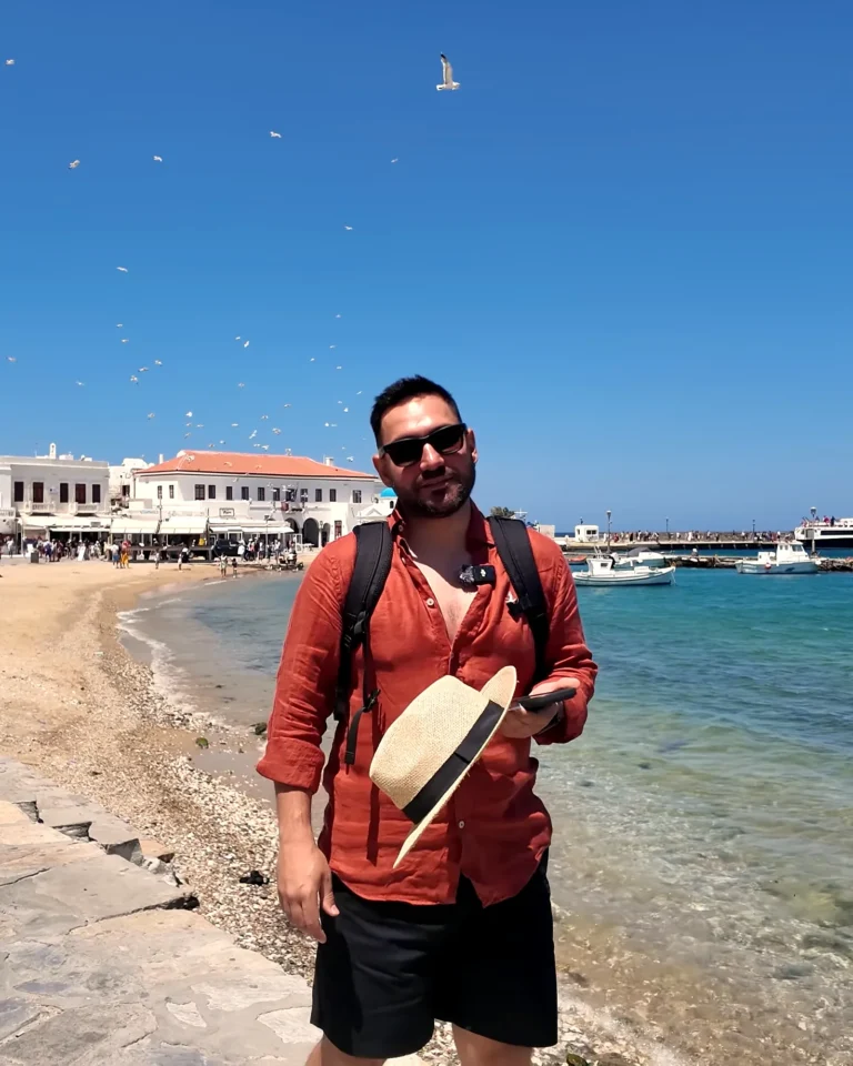 Mykonos Eski Liman sahilinde balıkçı tekneleri, martılar ve arkada beyaz Chora evleri