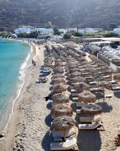 Mykonos (Mikonos) Adası Gezi Rehberi: A'dan Z'ye Seyahat İpuçları Mykonos Psarou plajında denize sıfır dizilmiş şezlong sıraları ve berrak turkuaz su