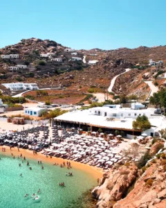 Mykonos (Mikonos) Adası Gezi Rehberi: A'dan Z'ye Seyahat İpuçları Mykonos Super Paradise koyunun genel görünümü; kumsal boyunca şezlonglar ve denize giren kalabalık