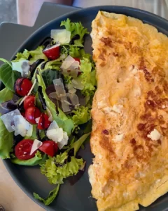 Rodos Cornet Bakery'de feta peynirli omlet ve balzamik soslu domatesli yeşil salatadan oluşan kahvaltı tabağı