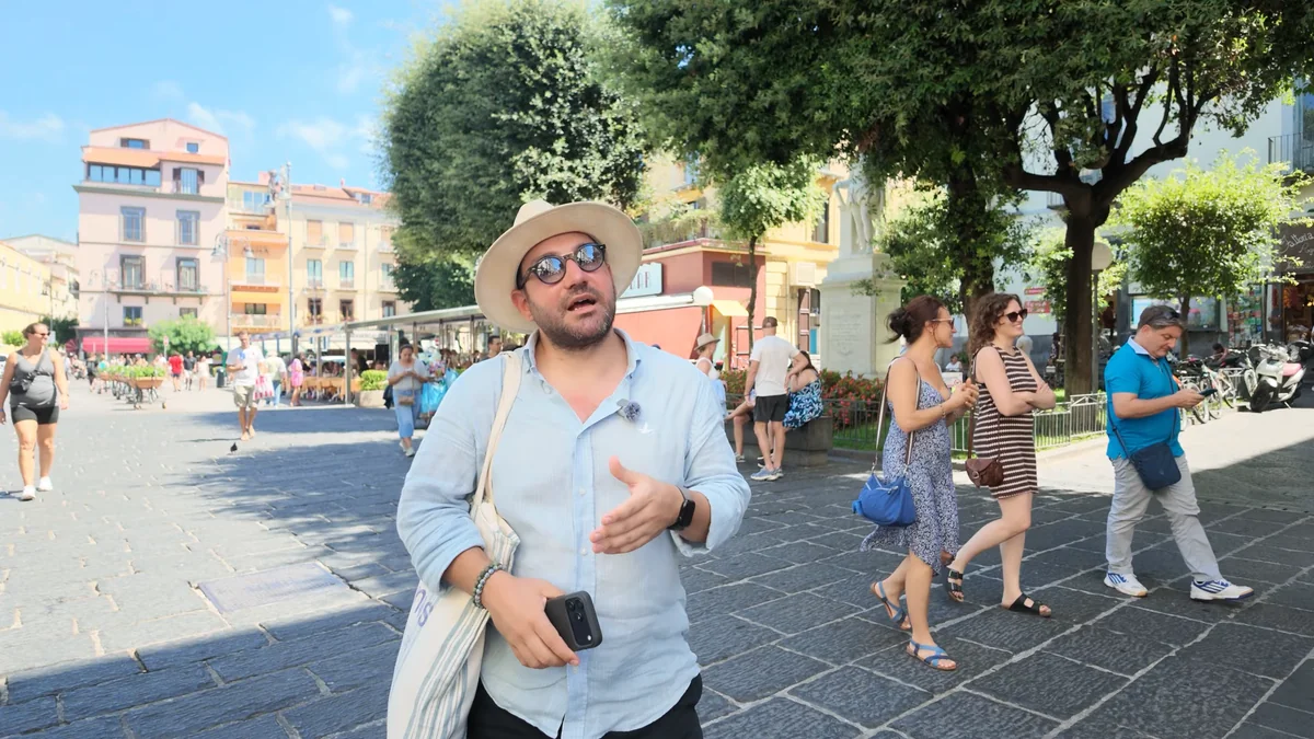Sorrento Piazza Tasso meydanı, çevresindeki ağaçlar ve yürüyen insanlar