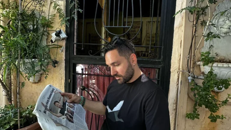 Plaka'da Mnisikleous Sokağı'nda sarmaşıklı bir kapının önünde gazete okuyan Halil Şımır