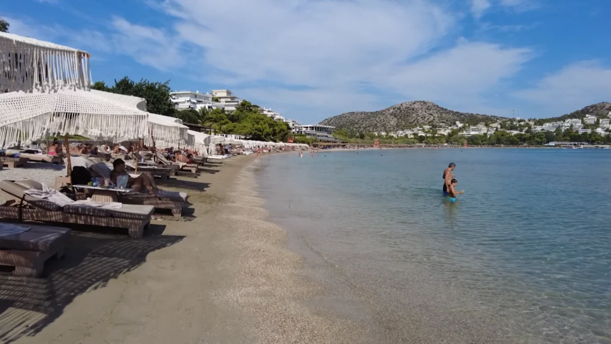 Atina Gezi Rehberi Atina Rivierası: Vouliagmeni tarafında şezlonglu plaj ve sığ berrak deniz