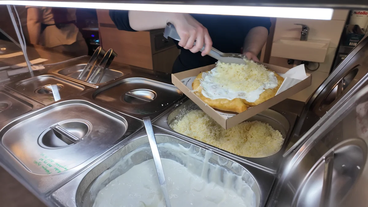 Budapeşte’de langoşun üzerine tezgahta sürülen ekşi krema ve rendelenmiş peynir