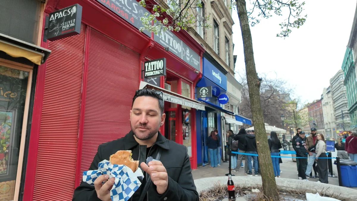 Budapeşte Smashy Burger’ın kırmızı cepheli dükkanının önünde elde tutulan smash burger