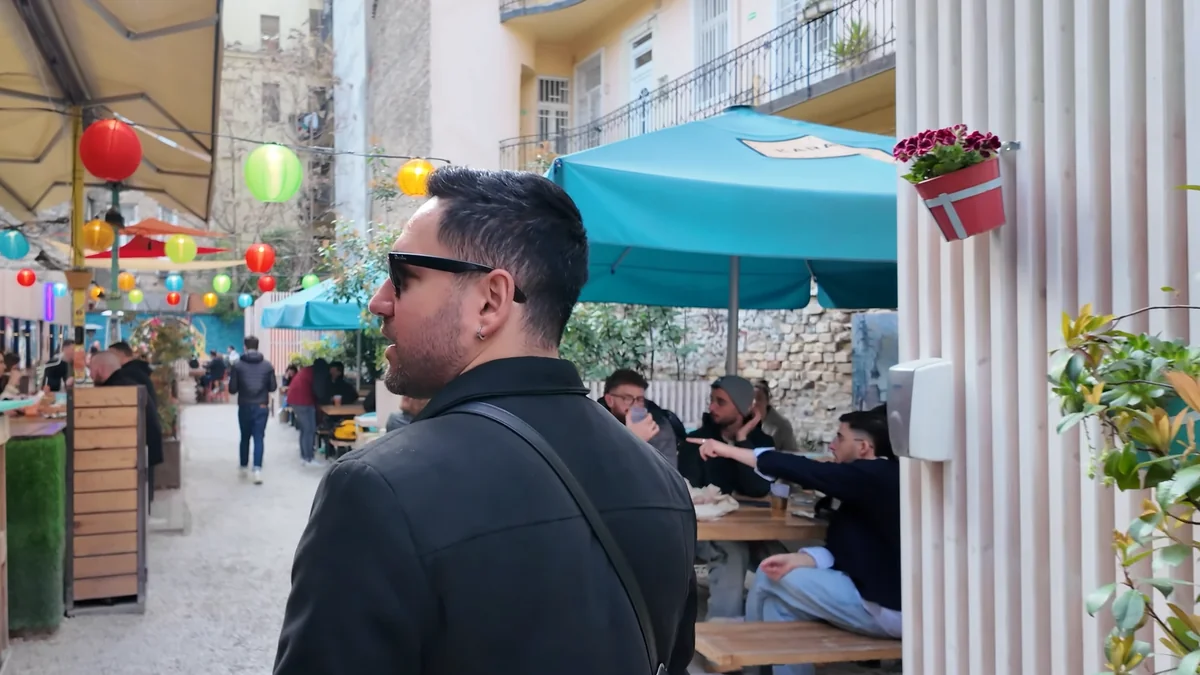 Budapeşte Karaván sokak lezzetleri avlusunda renkli fenerler, turkuaz şemsiyeler ve ahşap piknik masaları