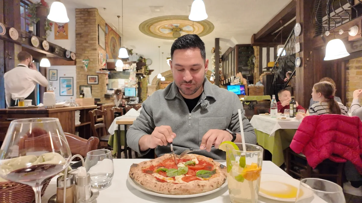 Budapeşte Trattoria Pomo D’Oro’nun tuğla duvarlı salonunda taş fırından çıkmış margherita pizza