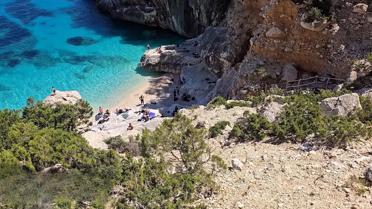Baunei Cala Goloritzé koyu: kayalıkların arasındaki beyaz çakıl plaj ve turkuaz su