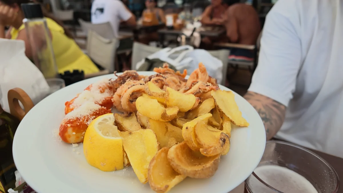 Poetto'daki Le Palmette Beach Club'da tabakta kızarmış deniz ürünleri, patates ve limon