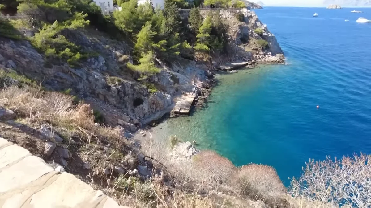 Hydra sahil yolundan turkuaz küçük bir koy ve çam ağaçları