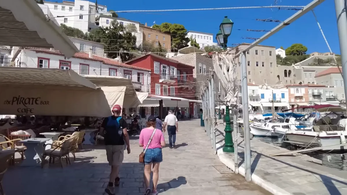 Hydra limanında renkli evler, kafeler ve yürüyen turistler